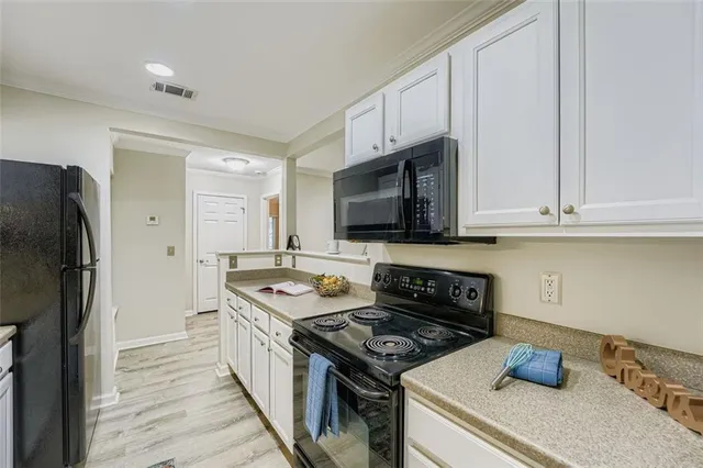 a kitchen with stainless steel appliances granite countertop a stove a refrigerator and a microwave