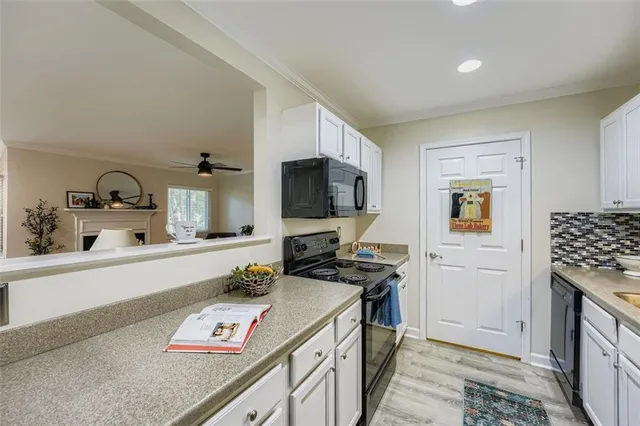 a kitchen with stainless steel appliances a stove a sink a refrigerator and a microwave