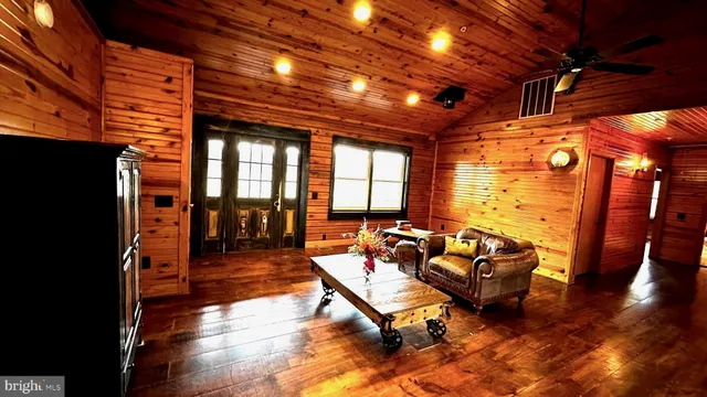 a living room with patio furniture and a wooden floor
