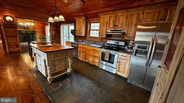 a kitchen with stainless steel appliances granite countertop a stove a sink and a refrigerator