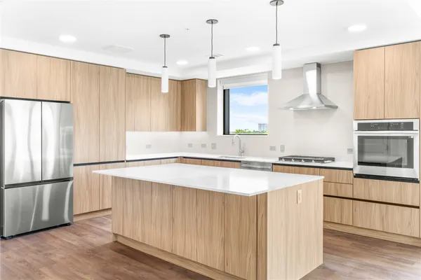 a kitchen with stainless steel appliances granite countertop a refrigerator a sink dishwasher a stove and a refrigerator
