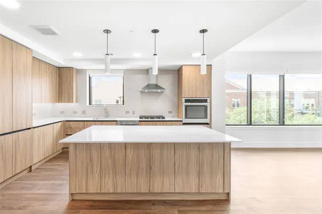 a kitchen with kitchen island a counter top a stove a sink and a window