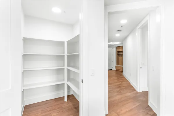 a view of a hallway with wooden floor and staircase