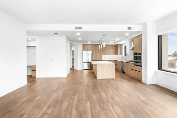 a view of a kitchen with a sink and dishwasher a refrigerator with wooden floor