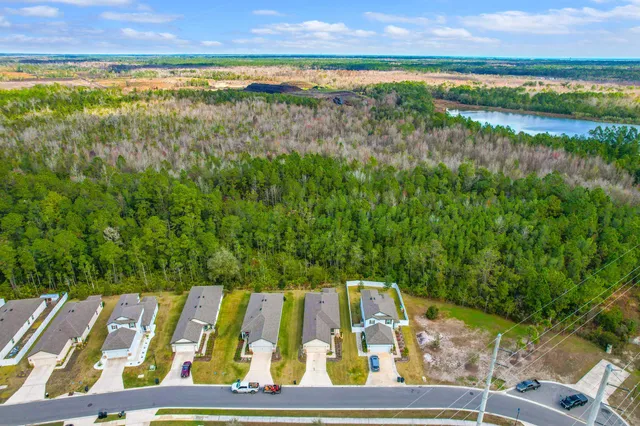 an aerial view of a house with swimming pool and lake view