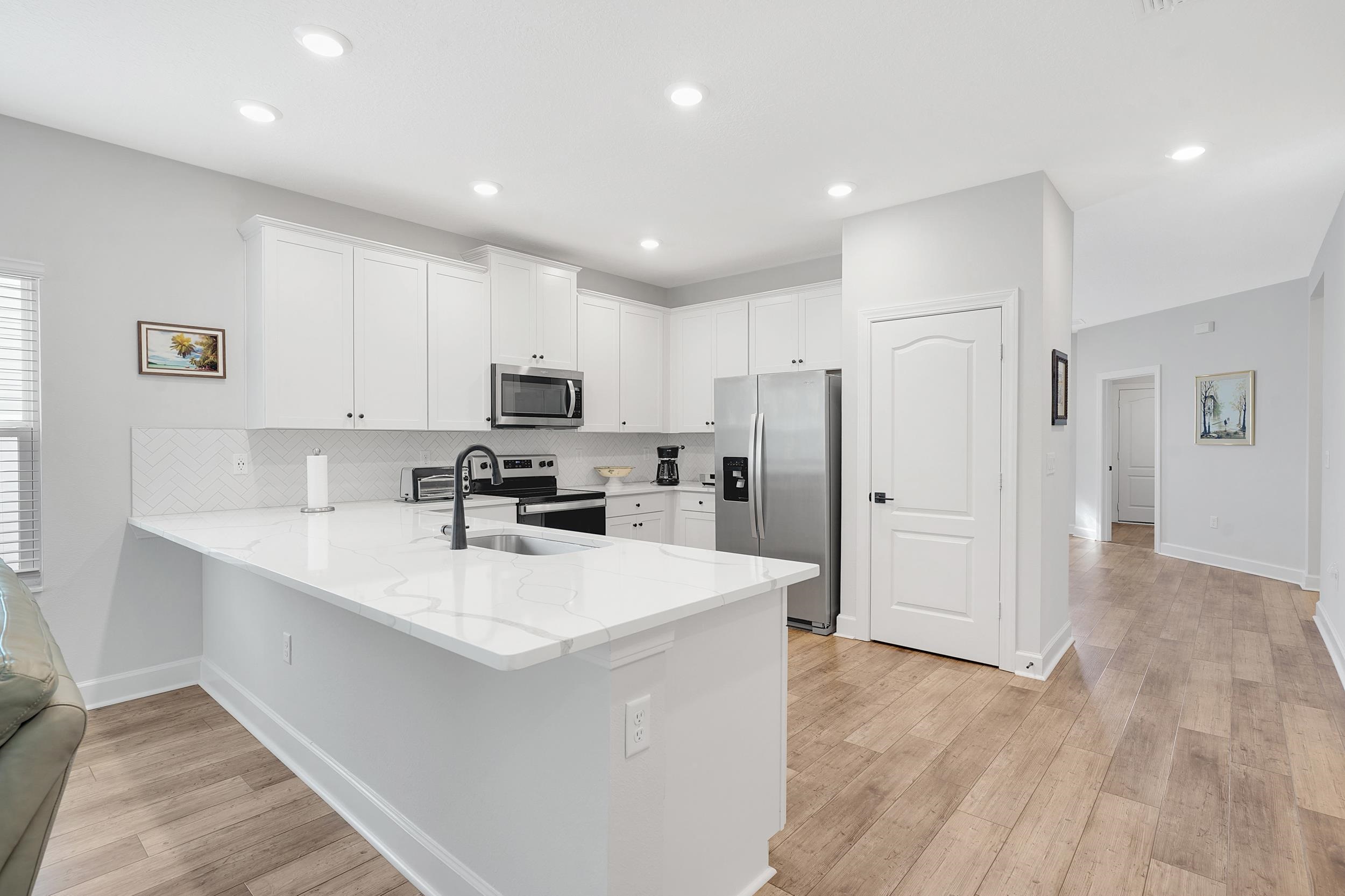 1014 Morgans Treasure Road St. Augustine, FL 32084 - Photo 7 of 31 a kitchen with stainless steel appliances a refrigerator sink and cabinets