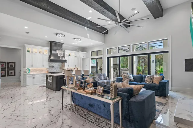 a living room with stainless steel appliances furniture and a large window