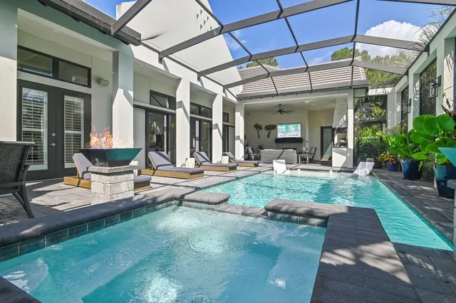 a view of a patio with couches chairs potted plants and floor to ceiling window