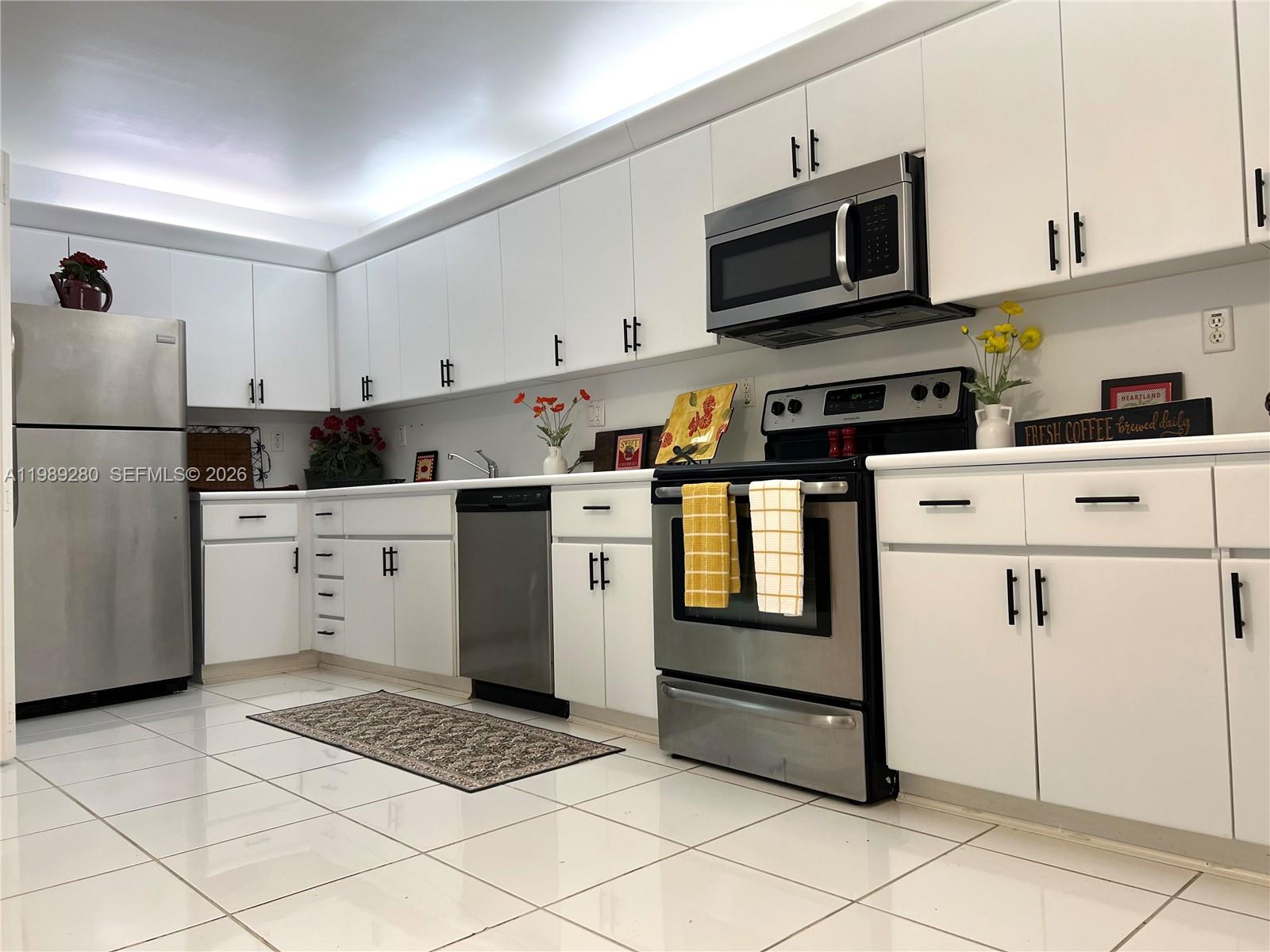 543 Racquet Club Road, Unit 33 Weston, FL 33326 - Photo 7 of 28 a kitchen with stainless steel appliances granite countertop a stove a sink and a microwave