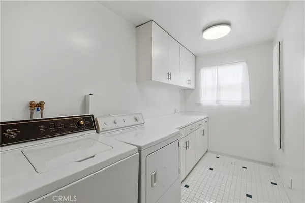 a utility room with cabinets washer and dryer