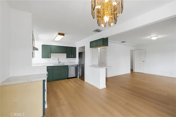 a kitchen with a sink cabinets and wooden floor