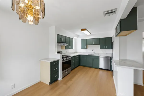 a kitchen with a sink cabinets and wooden floor