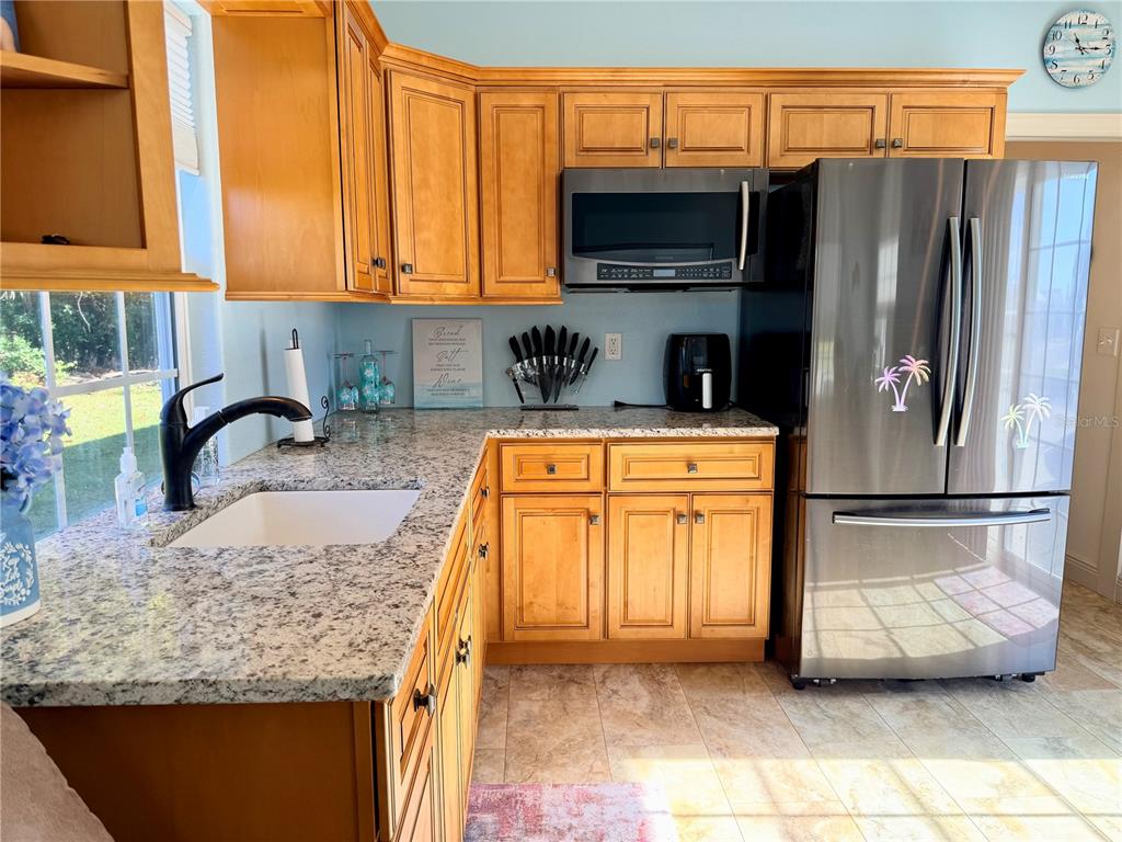 9357 Southeast 49th Terrace Webster, FL 33597 - Photo 17 of 39 a kitchen with stainless steel appliances granite countertop a refrigerator stove and sink