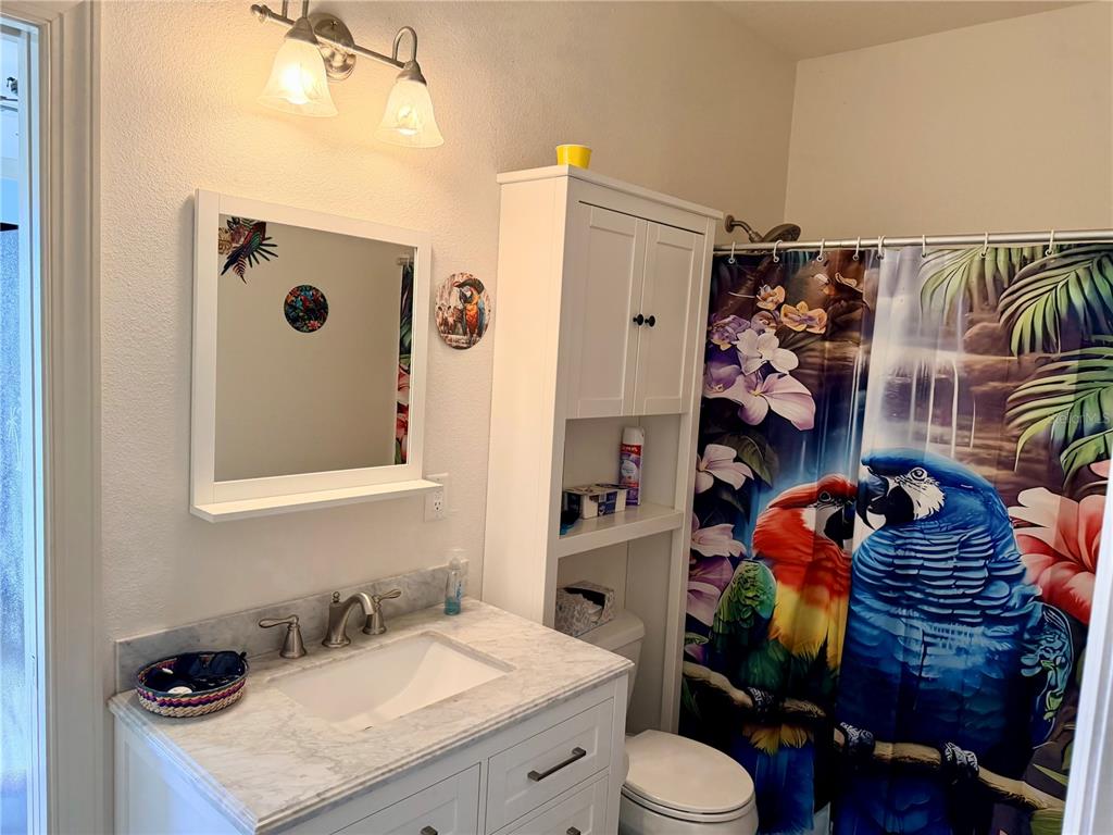 9357 Southeast 49th Terrace Webster, FL 33597 - Photo 21 of 39 a bathroom with a sink toilet and shower curtain