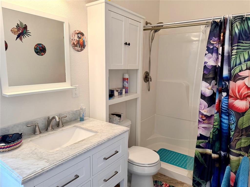 9357 Southeast 49th Terrace Webster, FL 33597 - Photo 22 of 39 a bathroom with a granite countertop sink toilet and shower