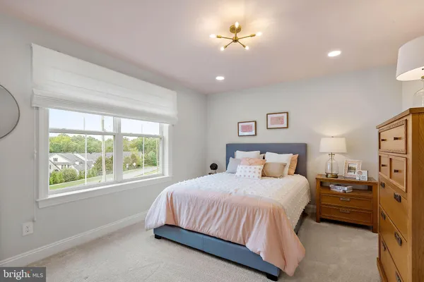 a bedroom with a bed ceiling fan and a window