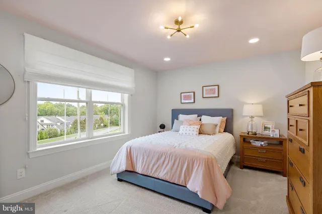 a bedroom with a bed ceiling fan and a window