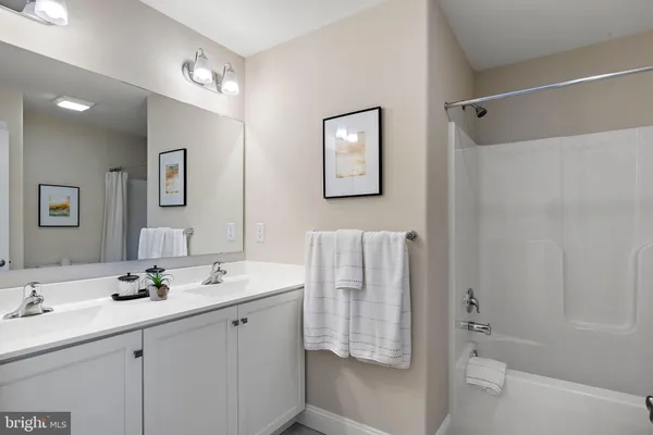 a bathroom with a double vanity sink a toilet and shower