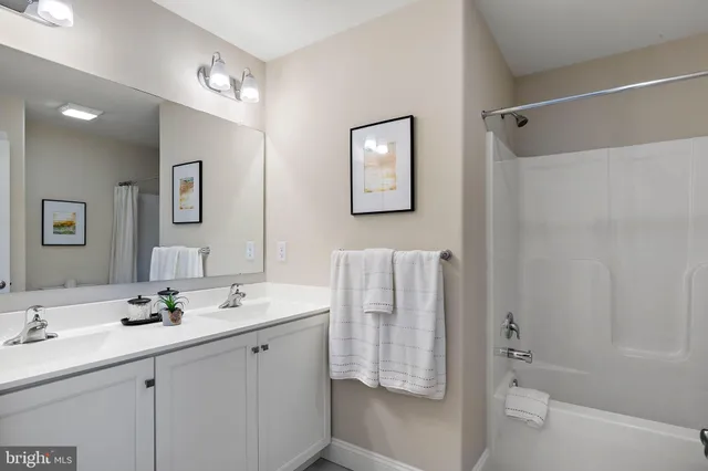 a bathroom with a double vanity sink a toilet and shower