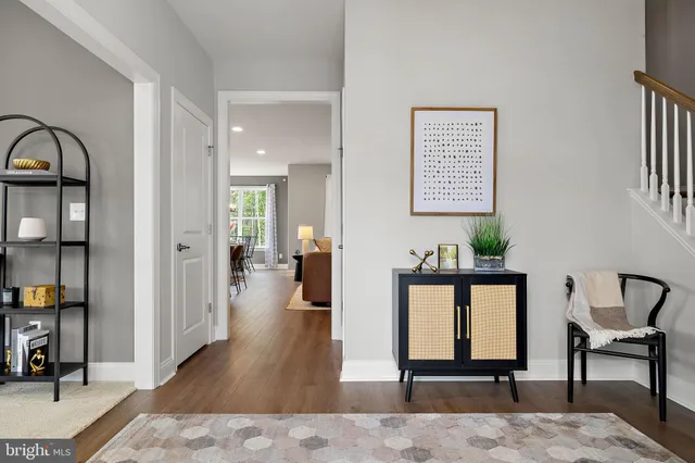 a view of a hallway with wooden floor and furniture