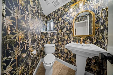 a bathroom with a toilet sink and mirror