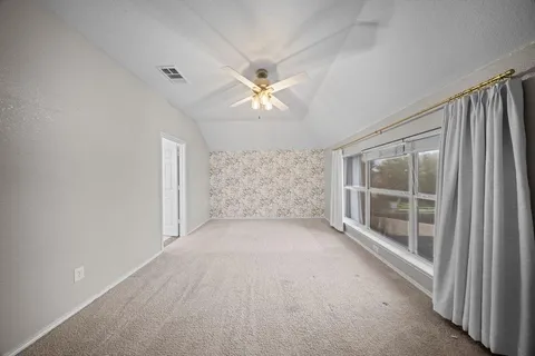 a view of empty room with a ceiling fan and window