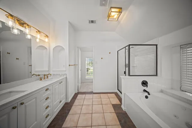 a spacious bathroom with a double vanity sink a mirror and a bathtub