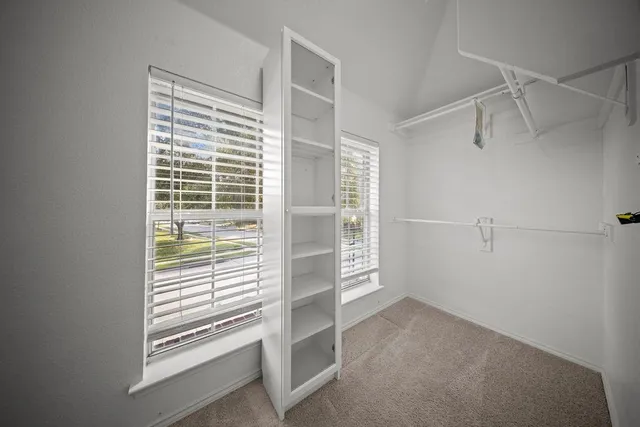 a view of walk in closet with empty racks