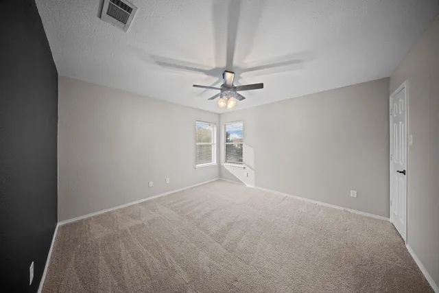 an empty room with a ceiling fan and a window