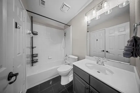 a bathroom with a sink a toilet a mirror and shower