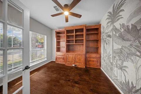 a view of an empty room with a window and kitchen