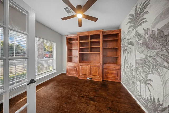 a view of an empty room with a window and kitchen