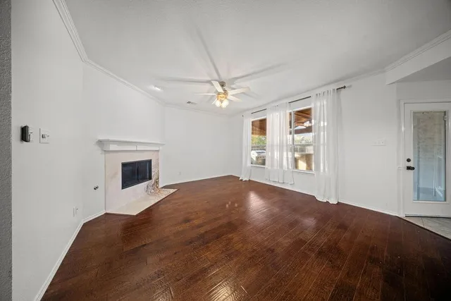 an empty room with windows and fireplace
