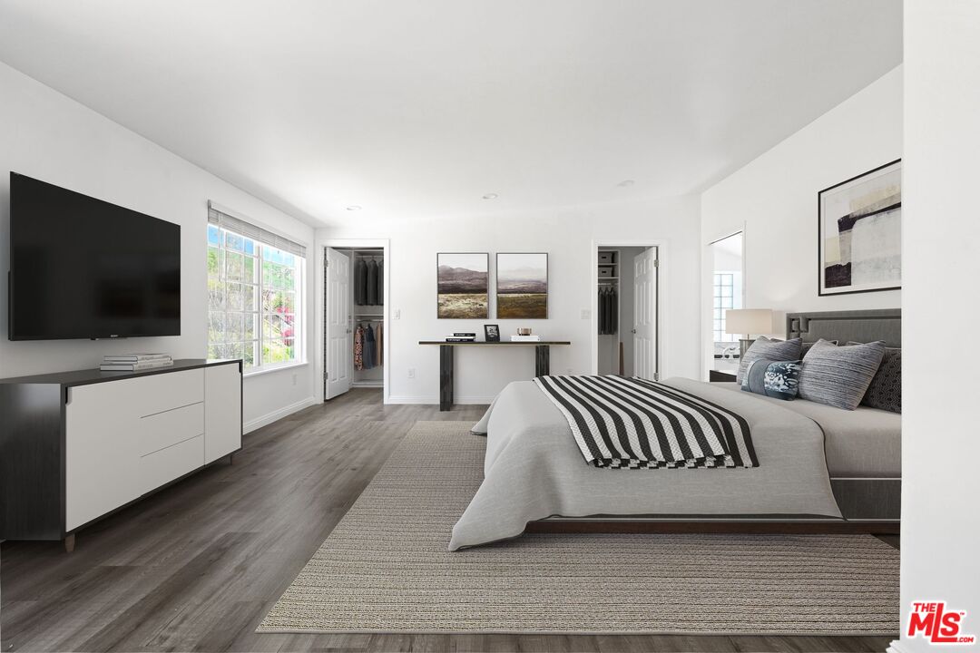 18657 Kirkcolm Lane Porter Ranch, CA 91326 - Photo 11 of 22 a spacious bedroom with a bed and a flat screen tv