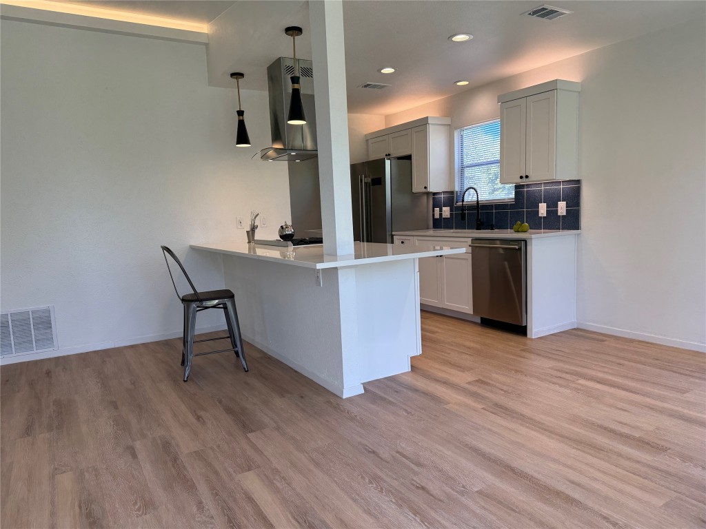 7313 Rhett Place Austin, TX 78744 - Photo 13 of 38 a kitchen with stainless steel appliances granite countertop a refrigerator and a stove top oven