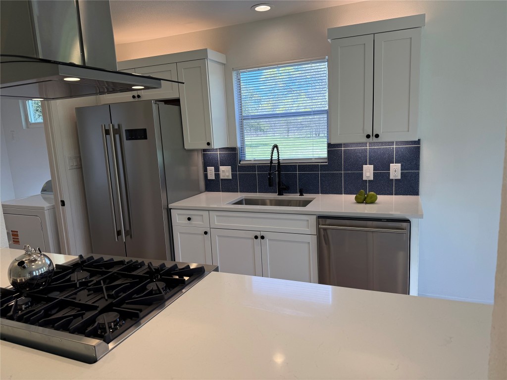 7313 Rhett Place Austin, TX 78744 - Photo 2 of 38 a kitchen with a refrigerator and a sink