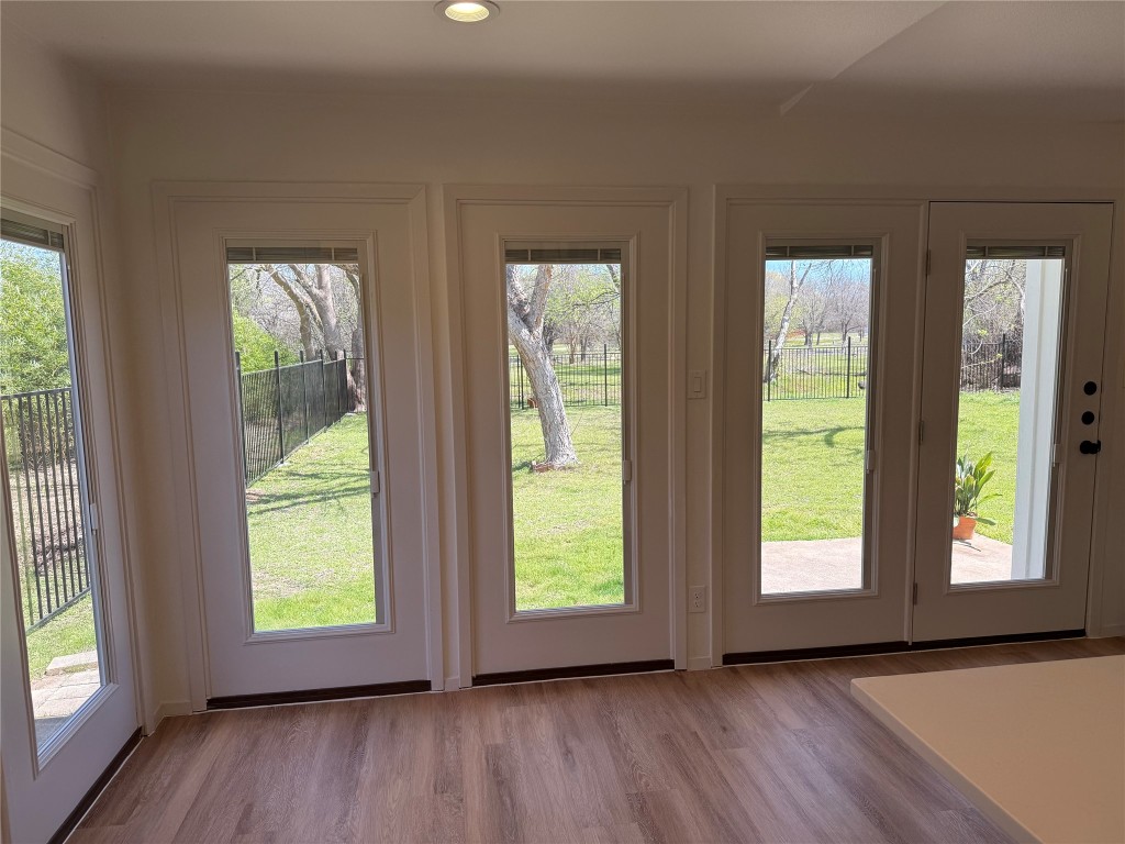 7313 Rhett Place Austin, TX 78744 - Photo 8 of 38 a view of an empty room with wooden floor and windows