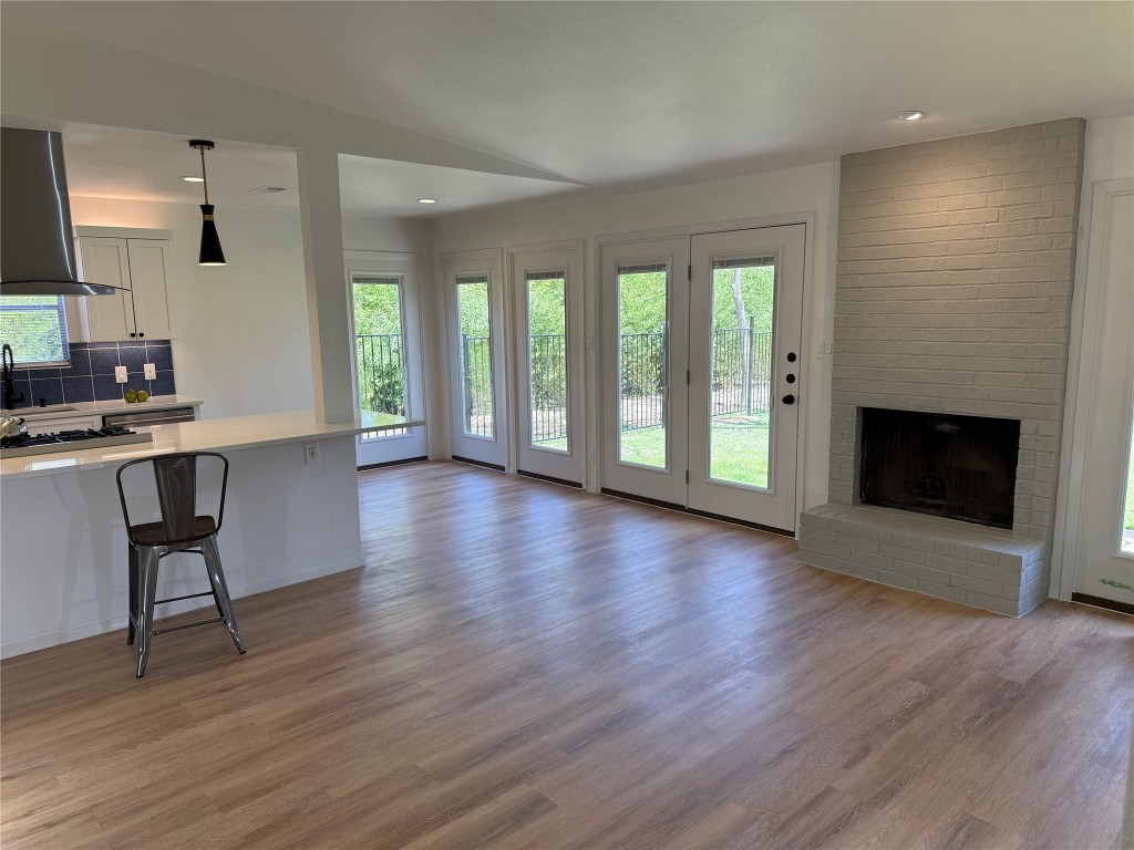 7313 Rhett Place Austin, TX 78744 - Photo 9 of 38 an empty room with wooden floor and fireplace