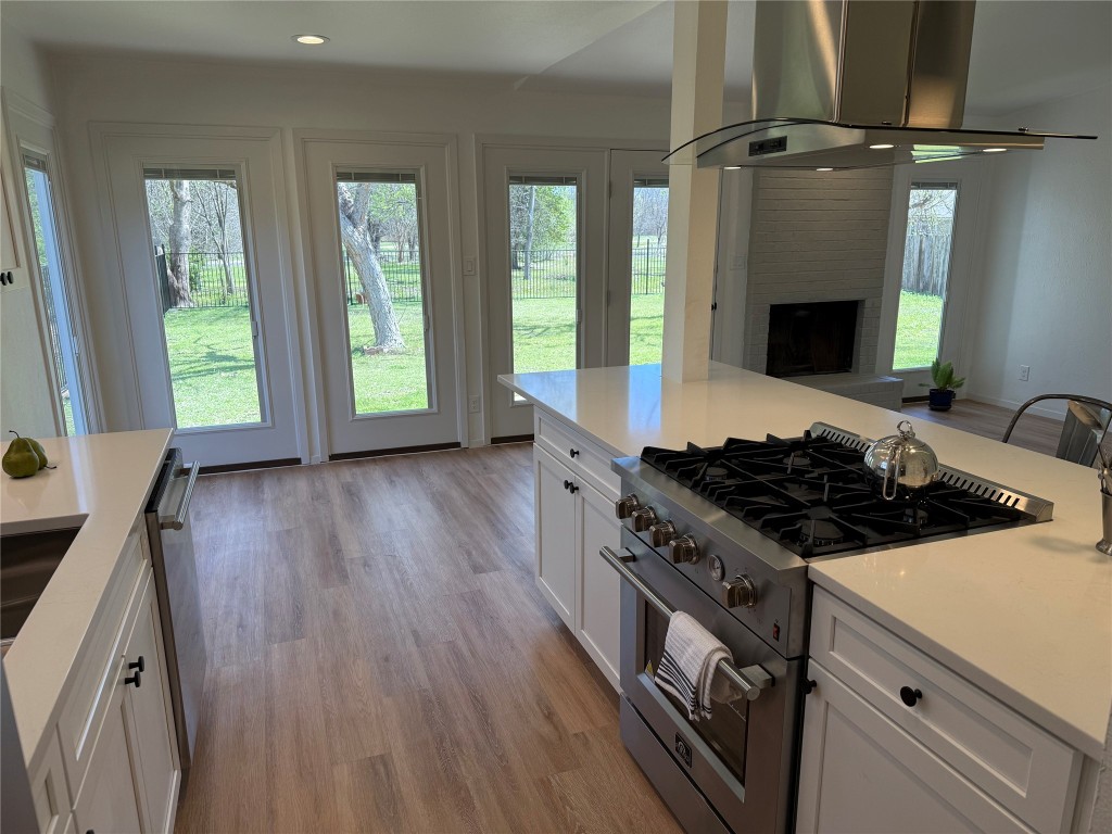 7313 Rhett Place Austin, TX 78744 - Photo 10 of 38 a kitchen with granite countertop a stove and a wooden floors