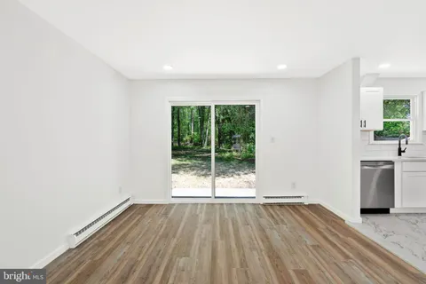 a view of kitchen with stainless steel appliances wooden floor and window