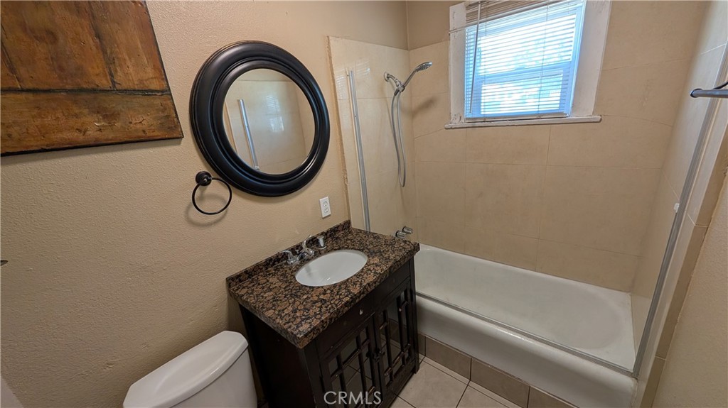 3445 4th Street Riverside, CA 92501 - Photo 14 of 20 a bathroom with a granite countertop sink mirror vanity and a toilet