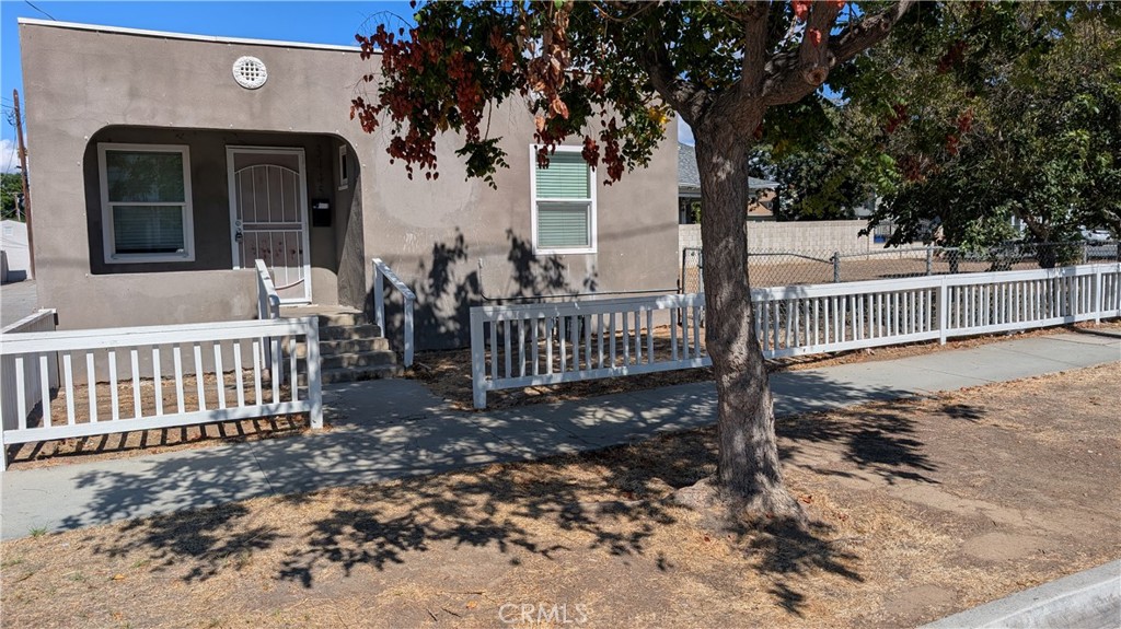 3445 4th Street Riverside, CA 92501 - Photo 2 of 20 a view of a wooden house with a large tree and wooden fence