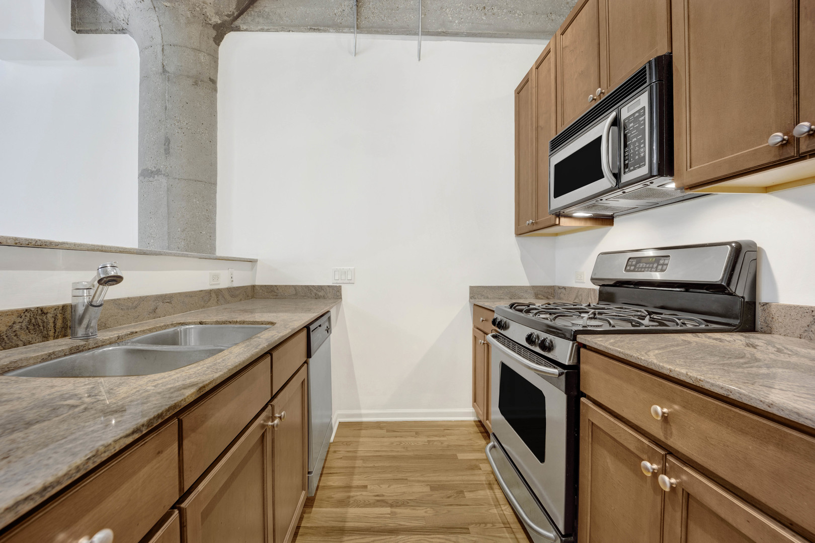 1070 West 15th Street, Unit 112 Chicago, IL 60608 - Photo 6 of 29 a kitchen with stainless steel appliances granite countertop a sink stove and microwave