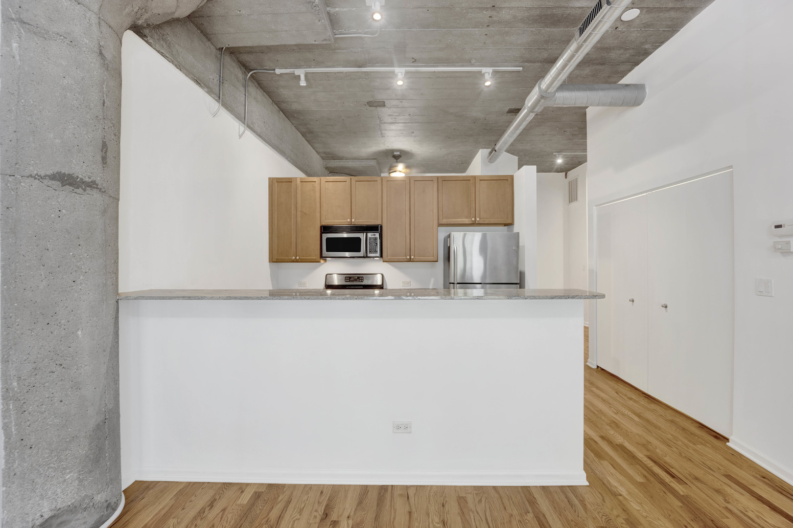 1070 West 15th Street, Unit 112 Chicago, IL 60608 - Photo 7 of 29 a kitchen with kitchen island a stove microwave and a refrigerator