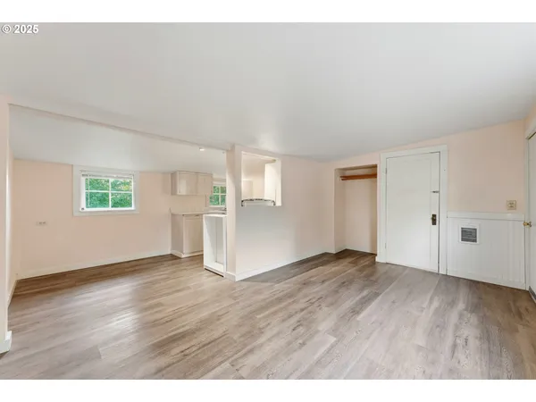 a view of an empty room with wooden floor