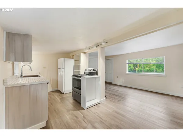 a view of a kitchen with a sink wooden floor and a window