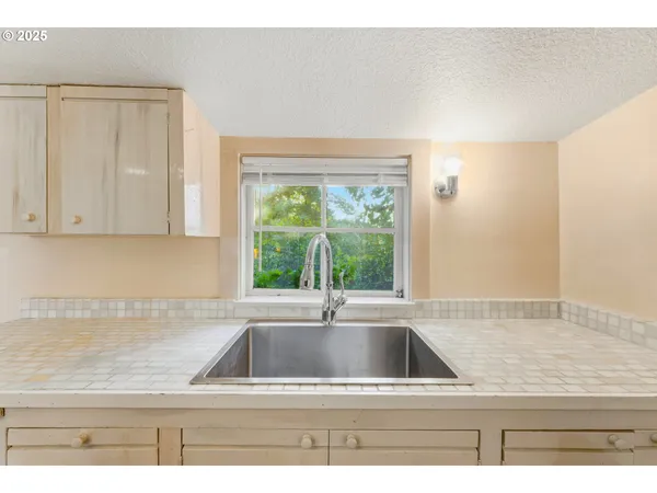 a view of kitchen sink window and cabinets