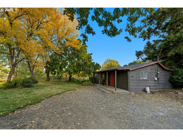 a view of a wooden house with a big yard