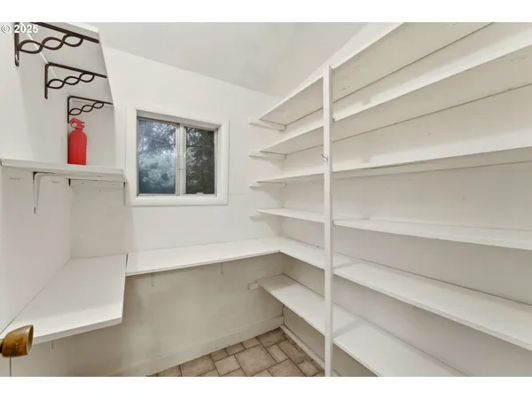 a view of an empty room with cabinet and a window