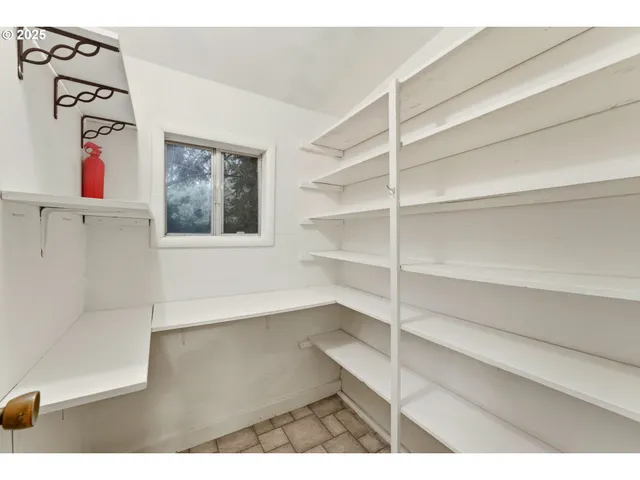 a view of an empty room with cabinet and a window